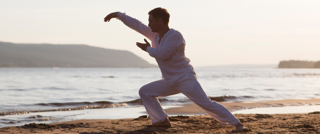 Mann am Strand praktiziert Qigong.